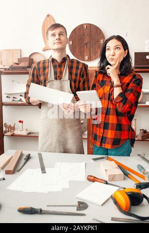 thoughtful man and a woman colleagues in the workshop Studio. Concept of handwork and carpentry Stock Photo