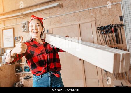 Happy Asian woman working in carpentry workshop Stock Photo
