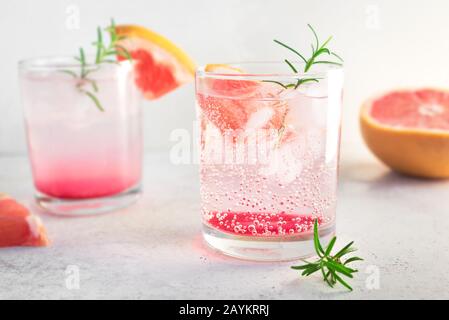 Grapefruit and rosemary cocktail, refreshing drink with ice. Greyhound cocktail, citrus sparkling soft drink, close up. Stock Photo
