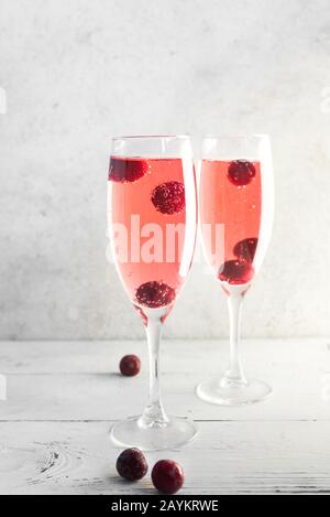 Kir Royal Champagne Cocktail on white, copy space. Flute glasses with berry sparkling champagne drink for celebrating or chilling. Stock Photo
