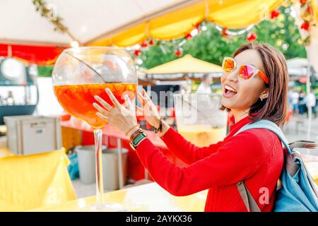 Funny Woman with big glass of cocktail on bar counter Stock Photo