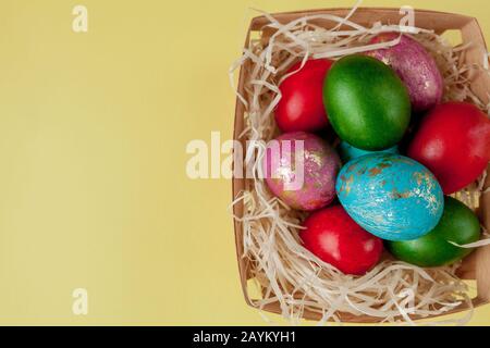 Happy Easter eggs yellow background. Golden shine decorated eggs in basket, for greeting card, promotion, poster. Copy space Stock Photo