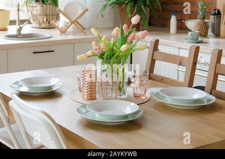 Stylish kitchen interior setting. Modern dining table setting with vase of flower Stock Photo