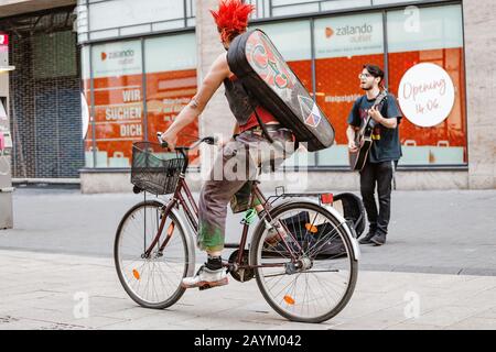 22 MAY 2018, LEIPZIG, GERMANY: cool young tattooed punk man riding bicycle at city street Stock Photo
