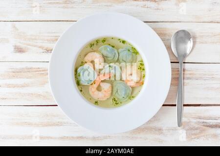 Soup dumplings and shrimp served with leek. On old wooden white background. Stock Photo