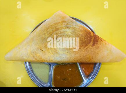 A Dosa is a Famous South Indian Food, cooked flat thin layered rice batter, made from a fermented batter. Stock Photo