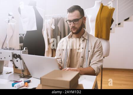 Seamstress works to new clothes ordered by internet client Stock Photo