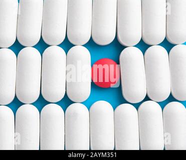 One pill separate from row of other pills. Concept of uniques Stock Photo