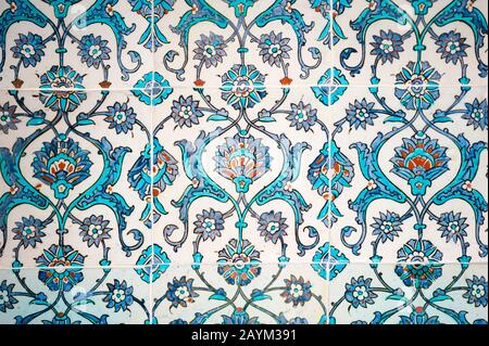 Photograph of medieval era glazed tile wall of intricate blue hand painted floral patterns in a Turkish Islamic mosque in Istanbul, Turkey Stock Photo