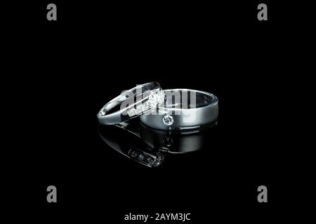 couple of luxury wedding diamond rings for bride and groom isolated on black background with shadow reflection and copy space. couple ring for wedding Stock Photo