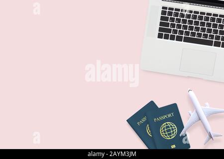 flat lay of passport , white plane model and computer laptop on pastel pink color background with copy space. travel , visa and vacation concept Stock Photo