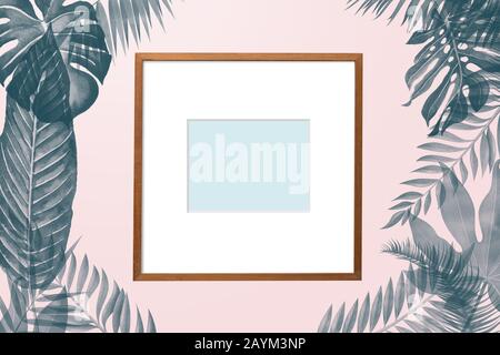 simply creative nature frame made of tropical palm and fern leaves on pink pastel background, top view Stock Photo