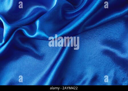 Blue silk background with folds.  Abstract texture of rippled satin surface Stock Photo