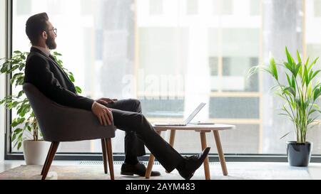 Horizontal banner middle eastern ethnicity businessman resting looking out window Stock Photo