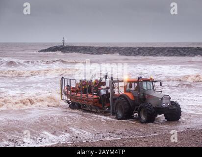 With Storm Dennis still blowing up a heavy swell in the English Channel, Sidmouth Lifeboat crew put out into a stormy and dangerous sea from their specially adapted sea tractor on a training exercise. Sidmouth Lifeboat is an independent lifeboat crew, (not RNLI) supported entirely by local community donations Stock Photo