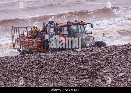 With Storm Dennis still blowing up a heavy swell in the English Channel, Sidmouth Lifeboat crew put out into a stormy and dangerous sea from their specially adapted sea tractor on a training exercise. Sidmouth Lifeboat is an independent lifeboat crew, (not RNLI) supported entirely by local community donations Stock Photo