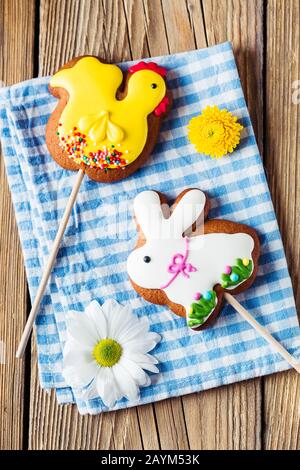 Easter gingerbread rabbit and chicken on a blue napkin on a wooden background Stock Photo