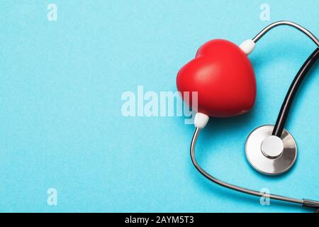 Toy heart and medical stethoscope on a blue background with copy space. Heart Disease Prevention Concept Stock Photo
