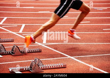 Sports man start running on the stadium track sprint Stock Photo