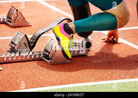 Prosthesis close-up of disabled person competition on the stadium track prepared to start racing Stock Photo
