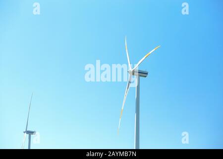 Electric wind mill turbines with blue sky background Stock Photo