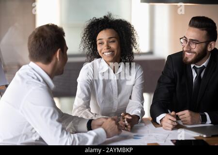 Three diverse professionals working together on new profitable project Stock Photo