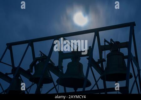 church bells against the background of the night sky and the bright moon Stock Photo
