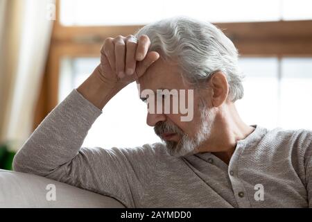 Depressed mature elderly hoary man lost in bad thoughts. Stock Photo