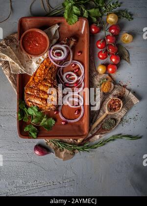 food photography of tasty grilled rack of pork with sauce, vegatables and spices in plate from above Stock Photo