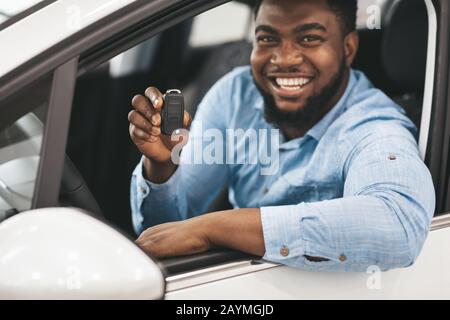 Smiling black guy driver sitting inside brand new car, looking at back  seat, closeup, copy space. Happy african american man enjoying driving  comforta Stock Photo - Alamy