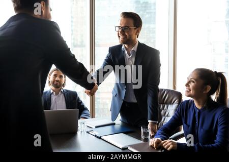 Happy successful businessman in suit shaking hand of applicant. Stock Photo