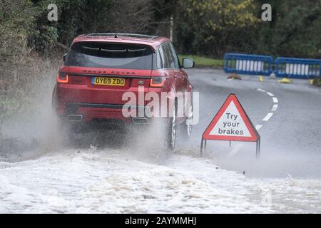 Majors Green, Birmingham, UK. 16th Feb, 2020. A Range Rover makes its way through a flooded Peterbrook Road in Majors Green, Birmingham as the river burst its banks due to heavy rainfall from Storm Dennis, closing the road to all but specialist vehicles. Pic taken 16/02/2020. Credit: Stop Press Media/Alamy Live News Stock Photo