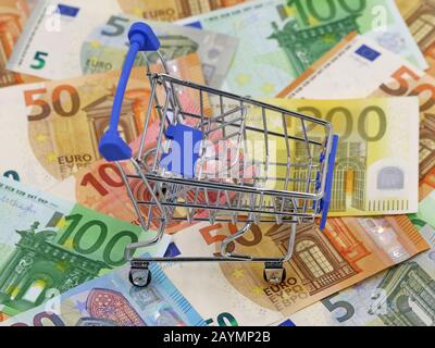empty shopping cart on euro banknotes, concept of savings for the future Stock Photo