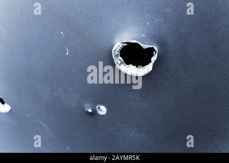 bullet hole in armored metal plate, war conflict and military tragedy concept Stock Photo