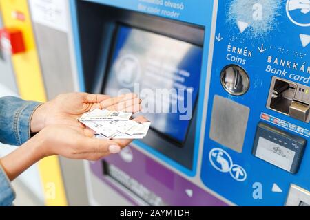 15 MAY 2018 BUDAPEST, HUNGARY: young woman buying tickets at vending machine for public transportation in Hungary Stock Photo
