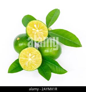 Pile of homegrown Asian limes with half cuts slices and green leaves isolated on white Stock Photo