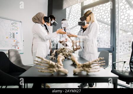 Male professor teacher using Virtual Reality Glasses to teach skeleton anatomy for multiethnic students in class. Education, VR, Tutoring, New Stock Photo