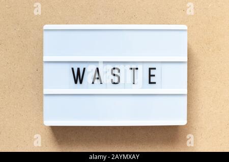 White lightbox with word waste on wood background Stock Photo