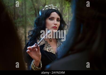 Portrait of a beautiful witch woman. She conducts rituals of black magic. Stock Photo