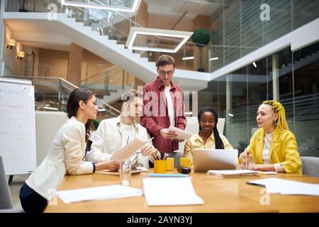 hardworking business people having discussion with colleagues in office, active people trying to make their brand known, team thinking how to make, ea Stock Photo