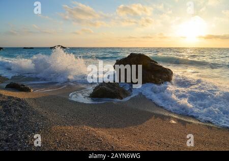 Golden hour on famous Kathisma Beach, Lefkada, Greece, windy day with lot of waves, short exposure, warm colors Stock Photo
