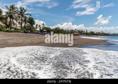 View of Pantai Babadan (Babadan beach), Canggu, Bali, Indonesia. Volcanic black sand, ocean waves, palm trees. Stock Photo