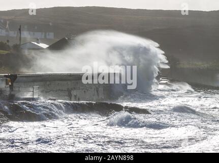 waves breaking over sea wall or coastal defence in west cork Ireland Stock Photo