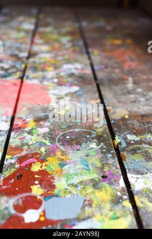 Artists workshop or studio bench covered with splattered paint built up in authentic texture on painted surface Stock Photo