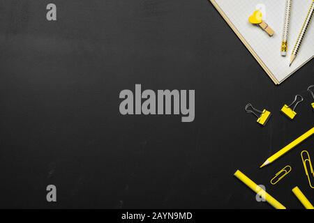 Top view mockup of Education's accessories with notebook, pencils, yellow color pencils, chalk, stationary with empty space on blackboard background, Stock Photo