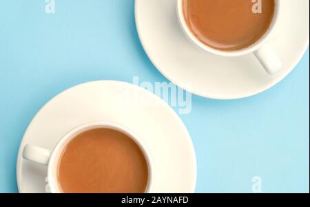 Two white cups coffee with milk, light blue background, top view. Americano. Copy space