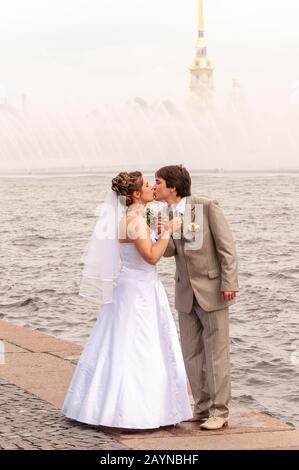 Newlyweds kissing on the embankment of the river Neva, St Petersburg, Russia Stock Photo