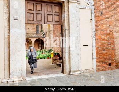 17 OCTOBER 2018, SIENA, ITALY: Old woman nun at the entrance to the monastery in Siena Stock Photo