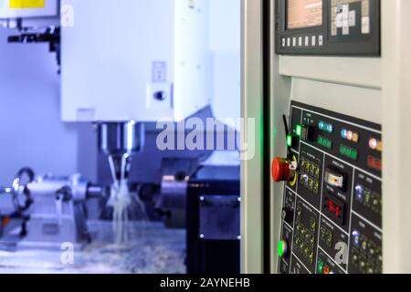 A modern 4-axis cnc vertical milling machine working with water cooling, selective focus on foreground, blur on background, Stock Photo