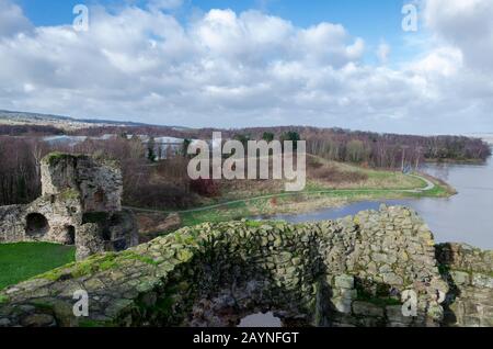 Flint Castle in Flintshire, North Wales with an unusually high spring tide. The flood water of the nearby River Dee approaches the walls of the castle Stock Photo